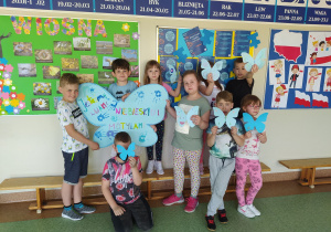 Dzieci prezentują plakat namalowany dłońmi